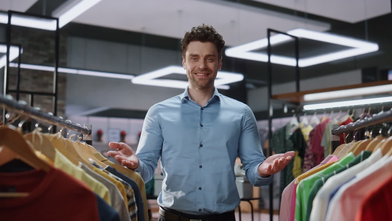 asistente feliz bienvenida a la tienda posando retrato de la cámara. trabajador de la tienda sonriendo