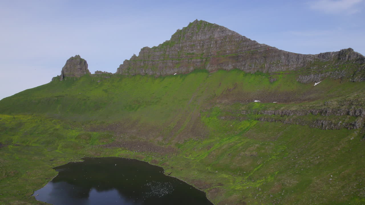 дрон поднимается над озером с экстремальным ландшафтом на заднем плане в отдаленной пустыне хорнстрадир, исландия