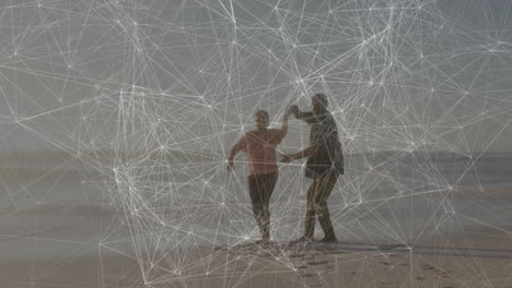 couple dancing barefoot on beach, illustrating technology network overlay with data nodes