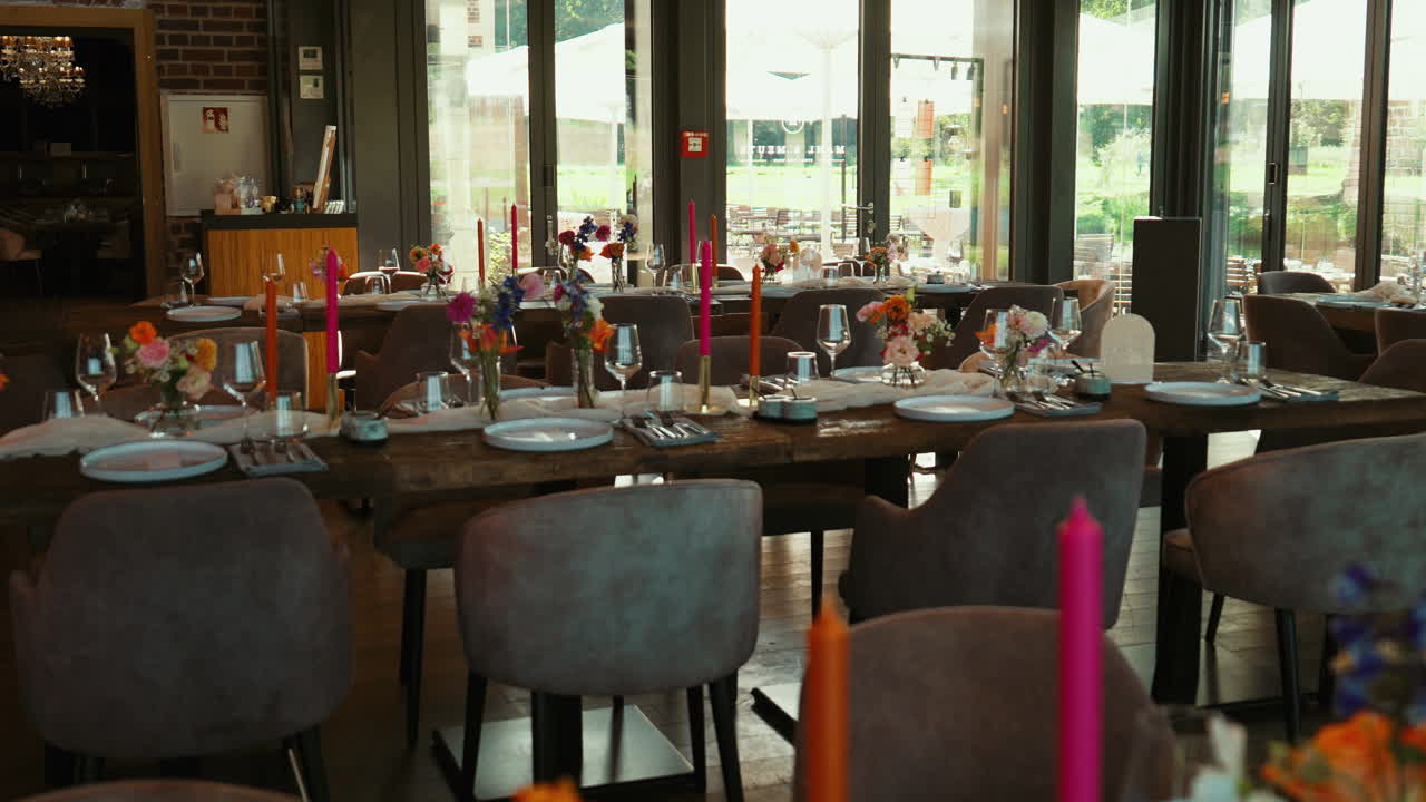 Indoor wedding reception hall filled with decorated tables, chairs, flowers, and candlelight, designed for a romantic and refined celebration