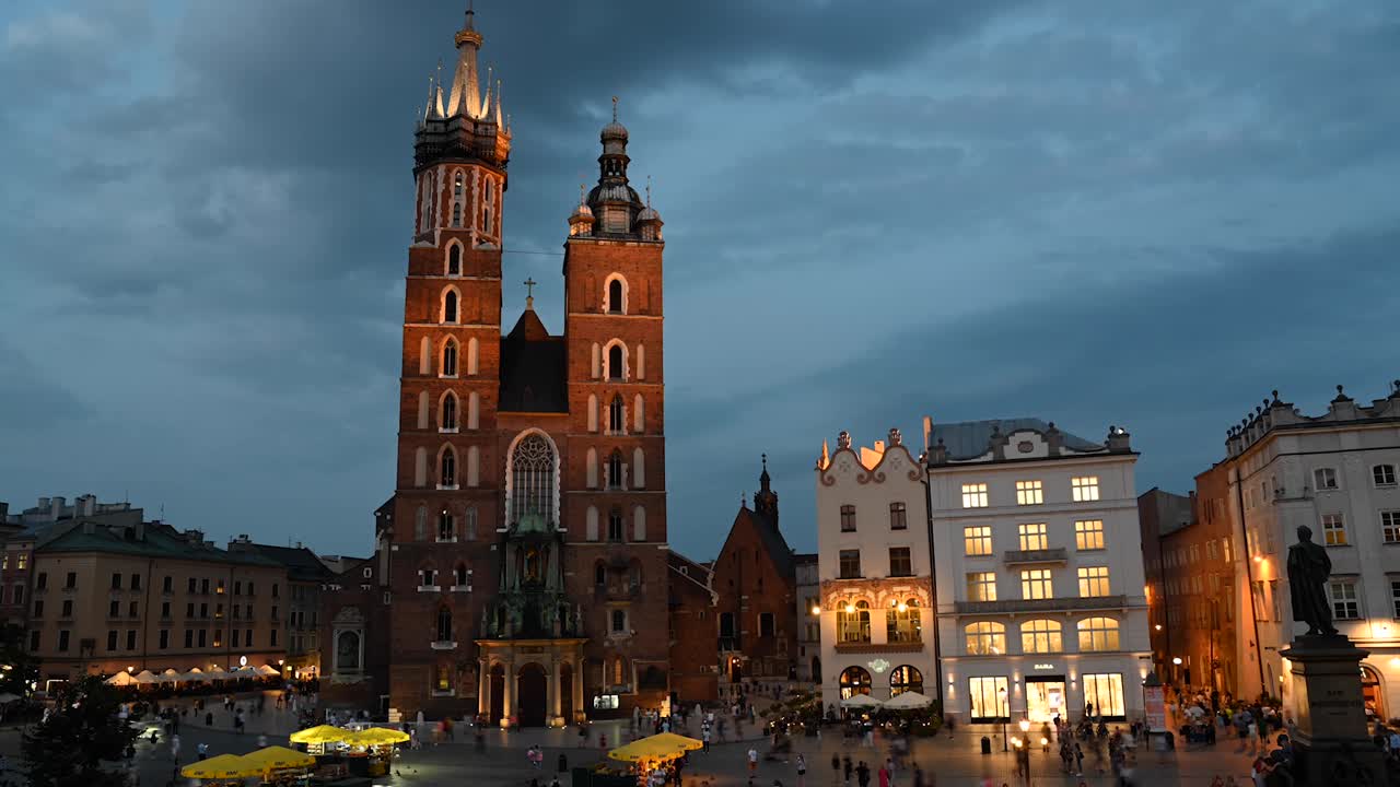 Time lapse view of the St. Mary's Basilica at dusk with evening lights in the city of Krakow