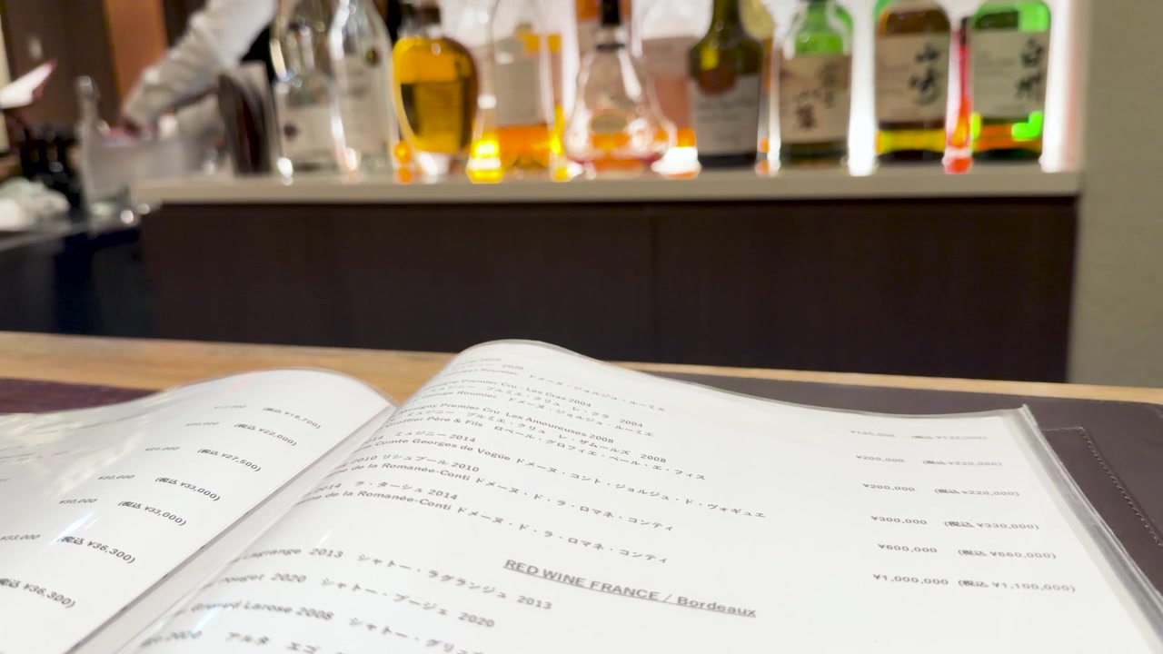 Gennemser et vinkort på en bar med flasker i baggrunden