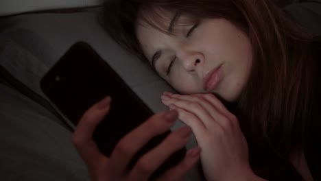 la chica trabaja en la computadora, acostada en la cama