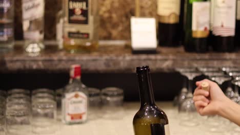 hands performing a bottle balancing trick on table