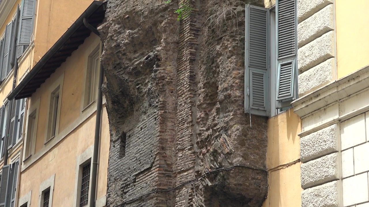 Antico muro di mattoni romano integrato nell'architettura di un edificio moderno