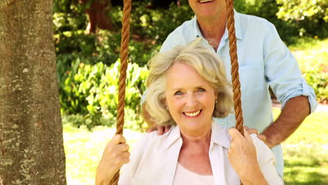 Retired-man-pushing-his-wife-on-swing