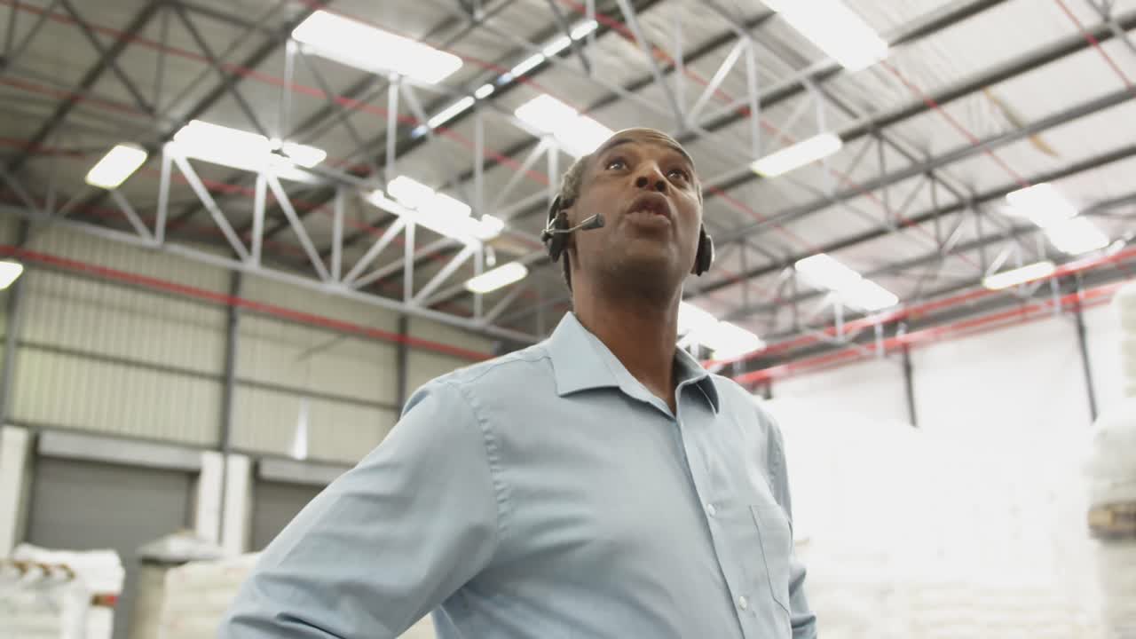 Close up of a male warehouse worker using headset in a storeroom 4k