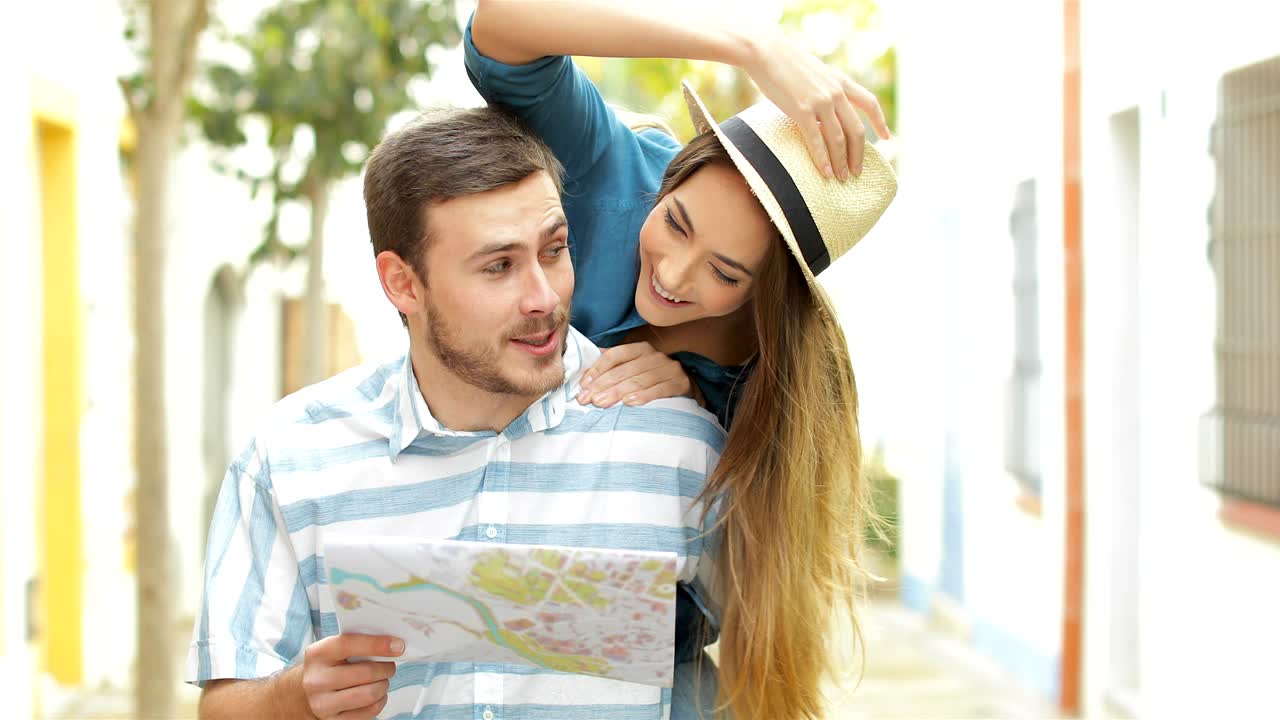 turistas divertidos bromeando y revisando el mapa