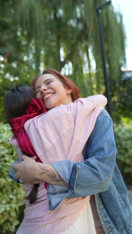 close friends hugging with a red ribbon