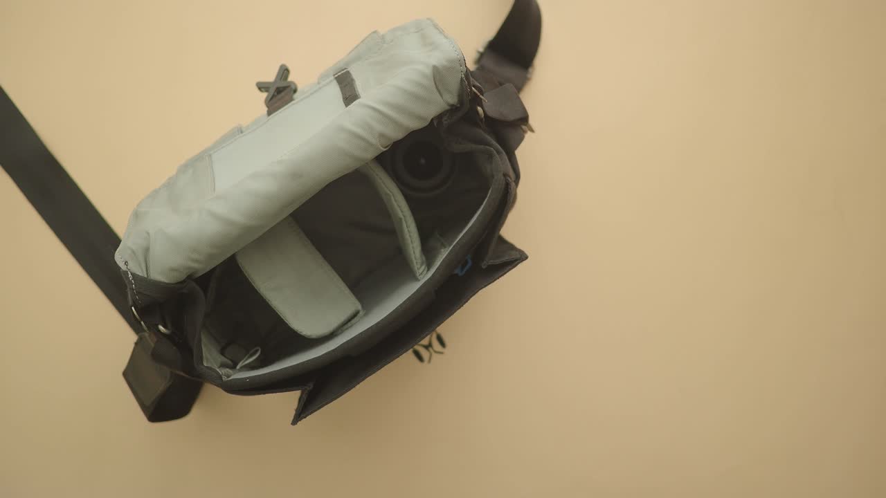 Person Placing Camera Lens and Body into Camera Bag