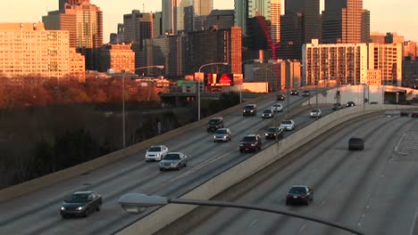 Die-Kamera-Schwenkt-Zur-Goldenen-Stunde-Von-Einer-Geteilten-Autobahn-Auf-Die-Skyline-Von-Chicago