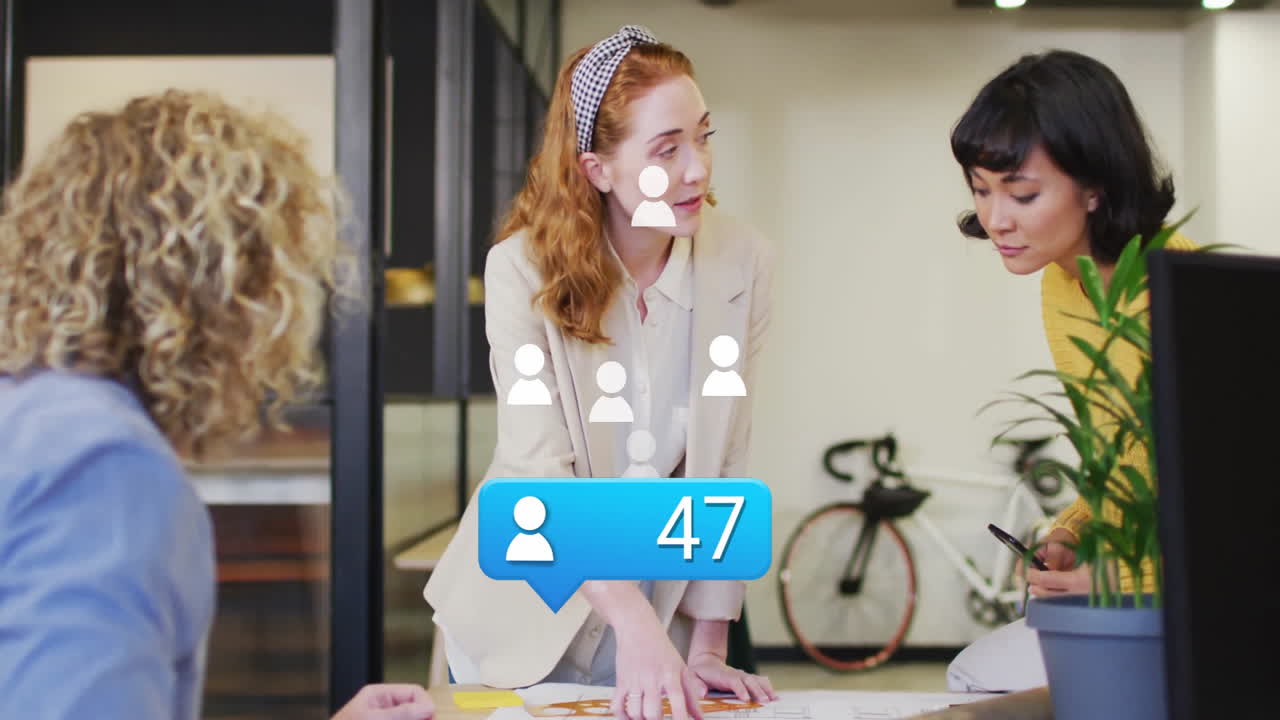Three colleagues reviewing architecture plans in office showing animated pen marks and sticky notes