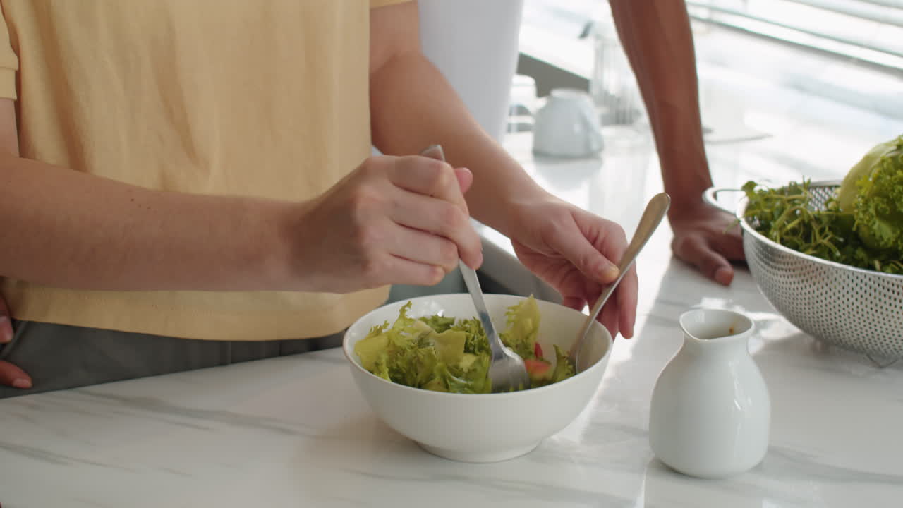 Husband Kissing Wife in Head when She Cooking Salad
