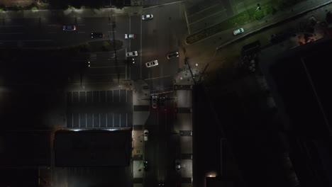 Aerial-birds-eye-overhead-top-down-view-of-cars-driving-through-intersection.-Descending-view-of-night-streets-in-city.-Dallas,-Texas,-US