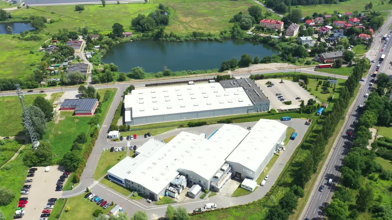 движущийся воздушный боковой снимок погрузочного дока промышленного склада, где множество грузовиков с полуприцепами загружают разгружают товары