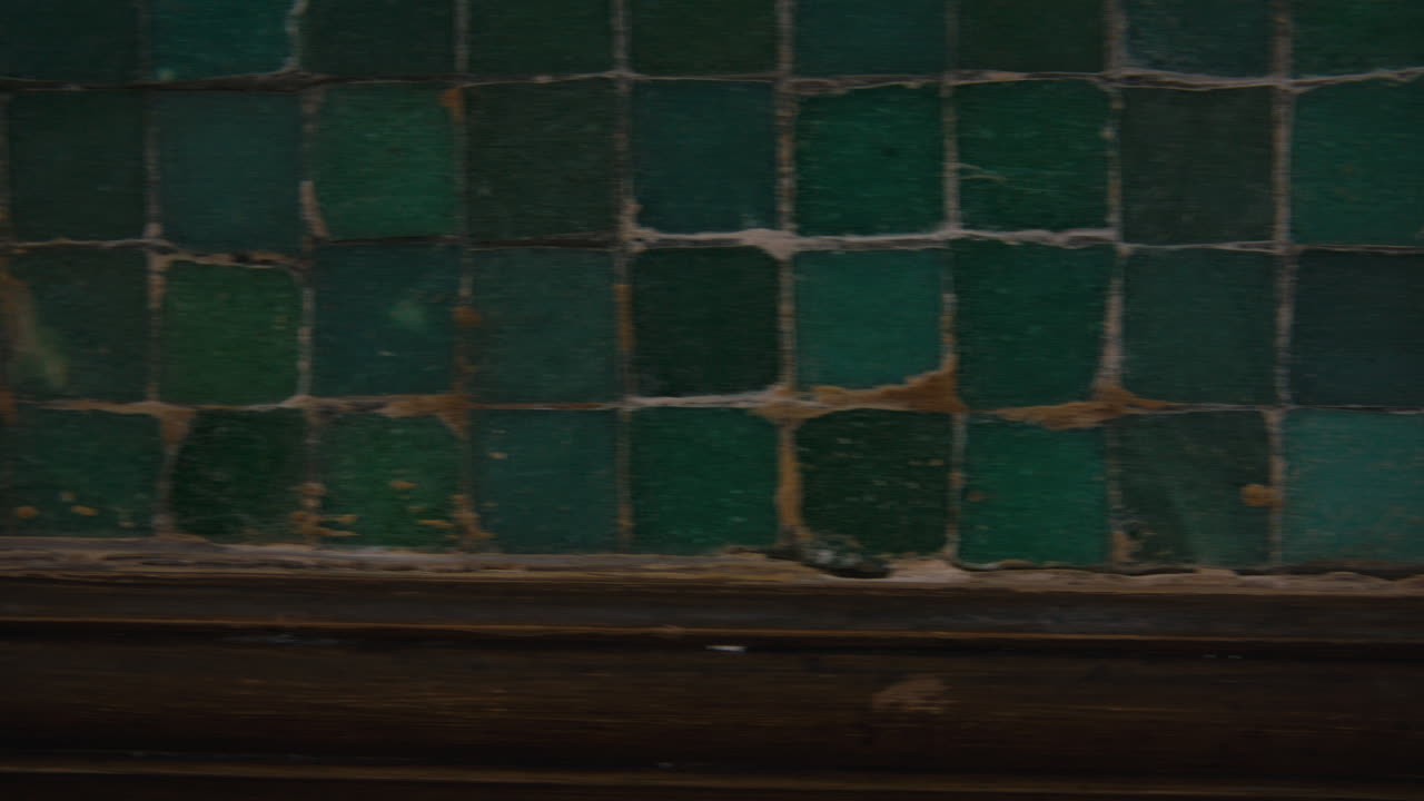 The camera swiftly moves right to left past a golden bitcoin propped up against a textured green mosaic wall, evoking urgency and momentum