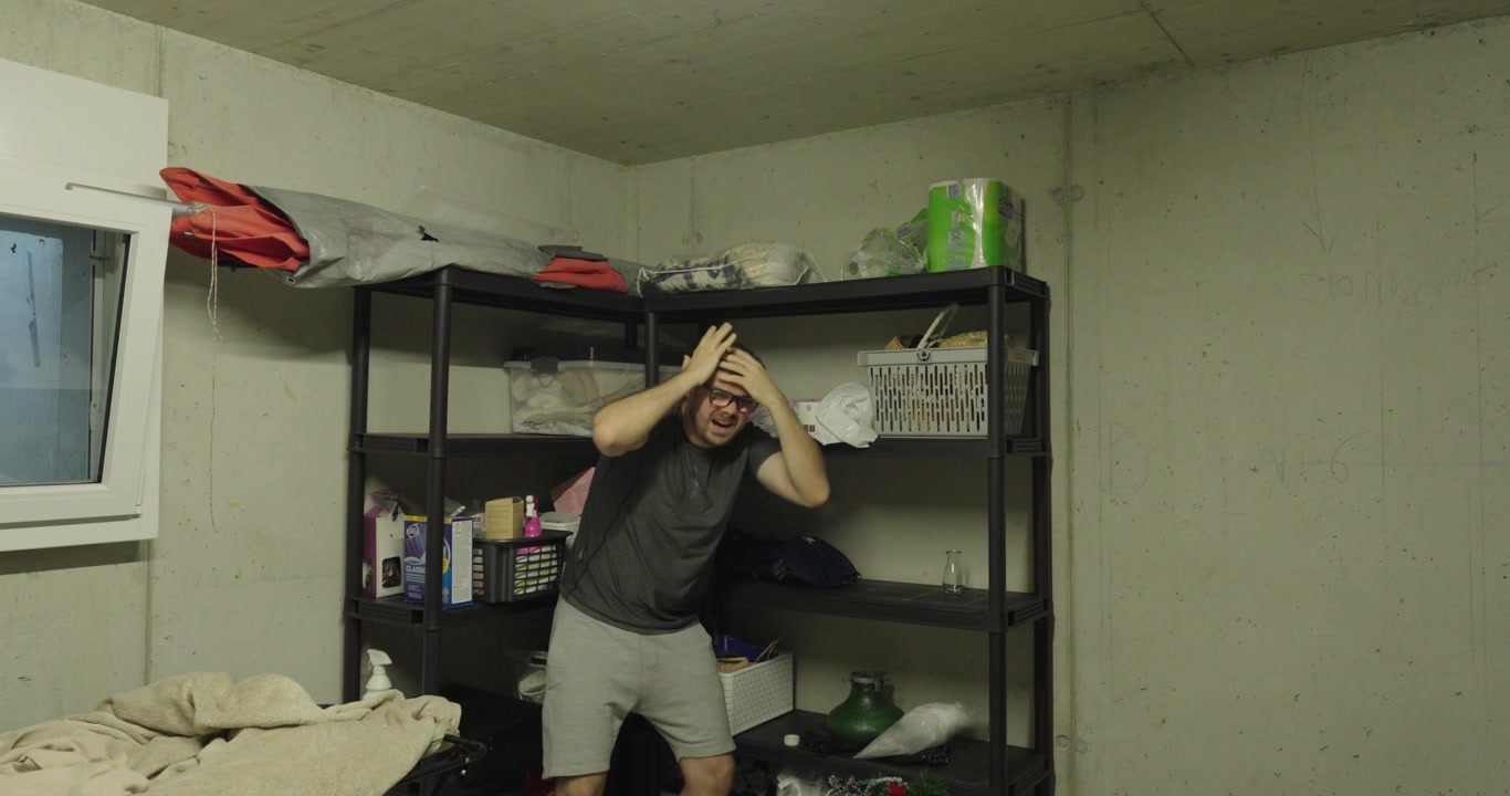 Man reaching for items on a storage shelf while objects fall toward his head. Concept of household accident, falling objects, risk, workplace safety, and storage hazards.