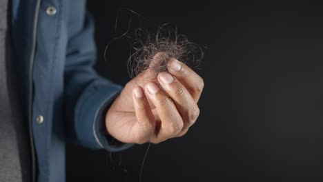 man holding a clump of hair