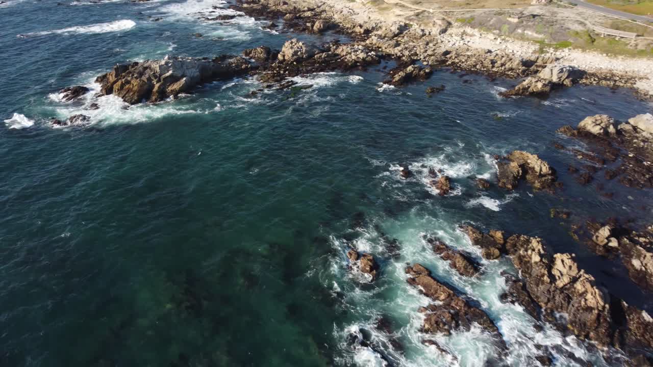 tomada de ángulo bajo de las olas en la playa de asilomar en monterey desde un dron