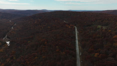 Autumn-fall-road-and-Lee-Creek-river-in-Arkansas,-high-above-aerial-shot