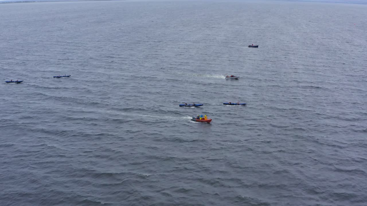 안전 보트와 함께 열린 바다 물에서 currach 보트 위에 드론 돌리