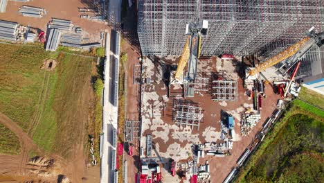 top down drone shot of roof of steel building on a construction site with employees