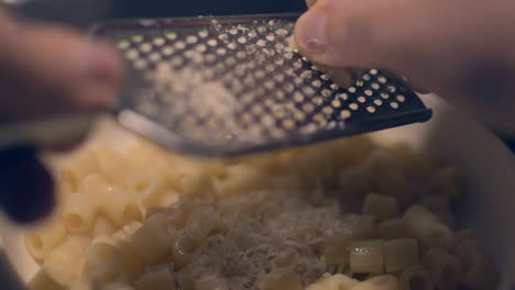 grattuggiare formaggio sulla pasta. grating cheese on pasta