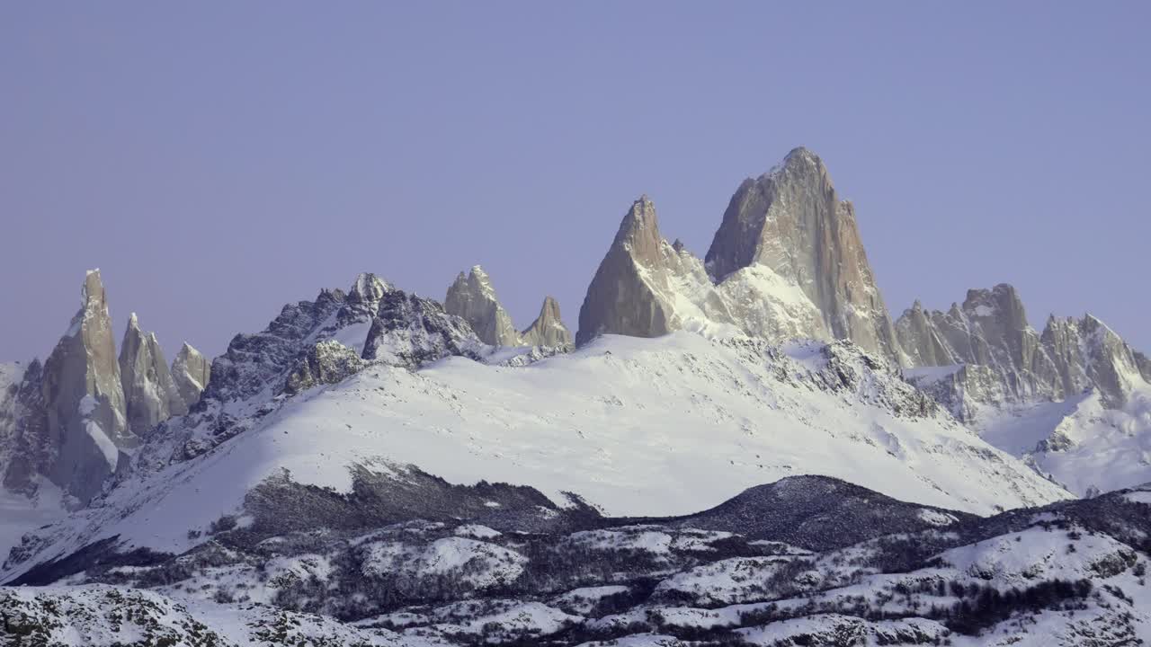 Le montagne Fitz Roy e Cerro Torre all'alba con cieli sereni e un paesaggio tranquillo in Patagonia.