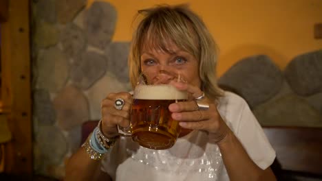 lady drinking and enjoying large glass of beer in a pub