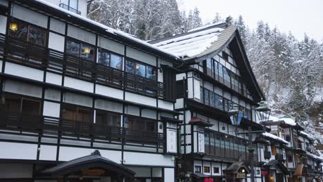 ginzan onsen, snow on traditional ryokan hot springs in japan, winter scene 4k