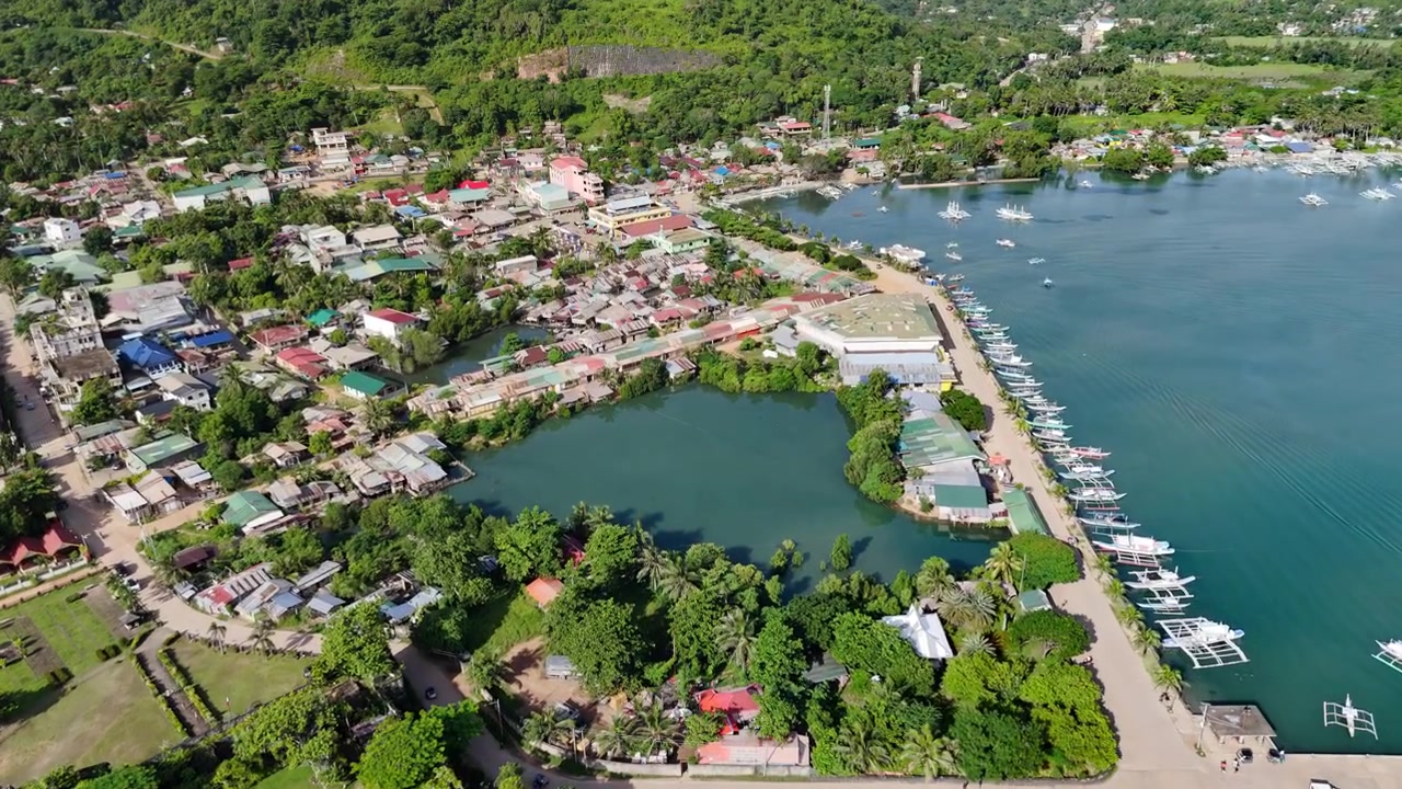 Ripresa con drone in avvicinamento e inclinazione verso il basso che rivela il Forte Santa Isabel e la città costiera di Taytay, Palawan. Il movimento aereo passa dal forte spagnolo in pietra corallina