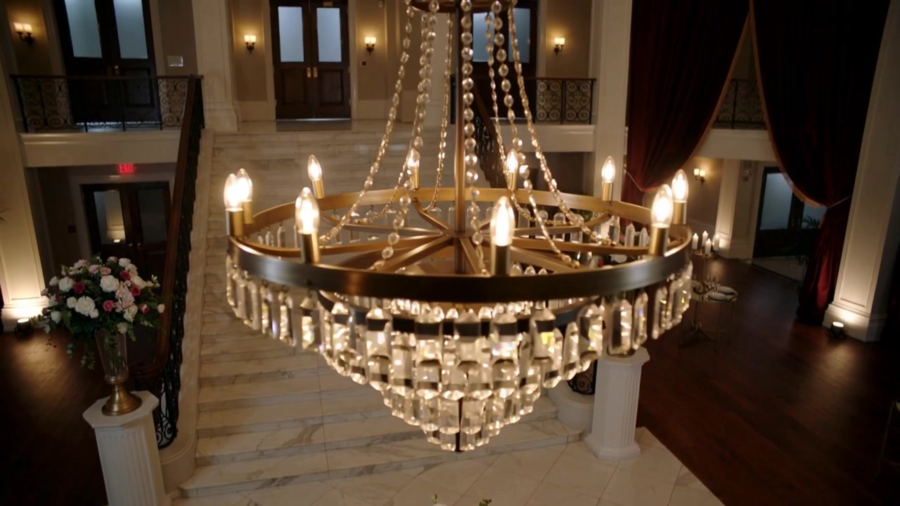 Inizio sequenza, lampadario di cristallo ornato che scende e si muove nell'ingresso, mostrando il pezzo centrale.
