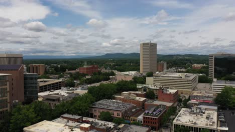 Toma-Aérea-Sobre-La-Ciudad-De-Greenville-En-Carolina-Del-Sur,-Edificios-Bajo-Un-Cielo-Azul-Con-Nubes