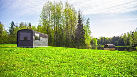 Cabina-De-Termomadera-Y-Sauna-De-Barril-En-El-Campo-Verde-Cerca-Del-Lago-Desde-El-Amanecer-Hasta-El-Día