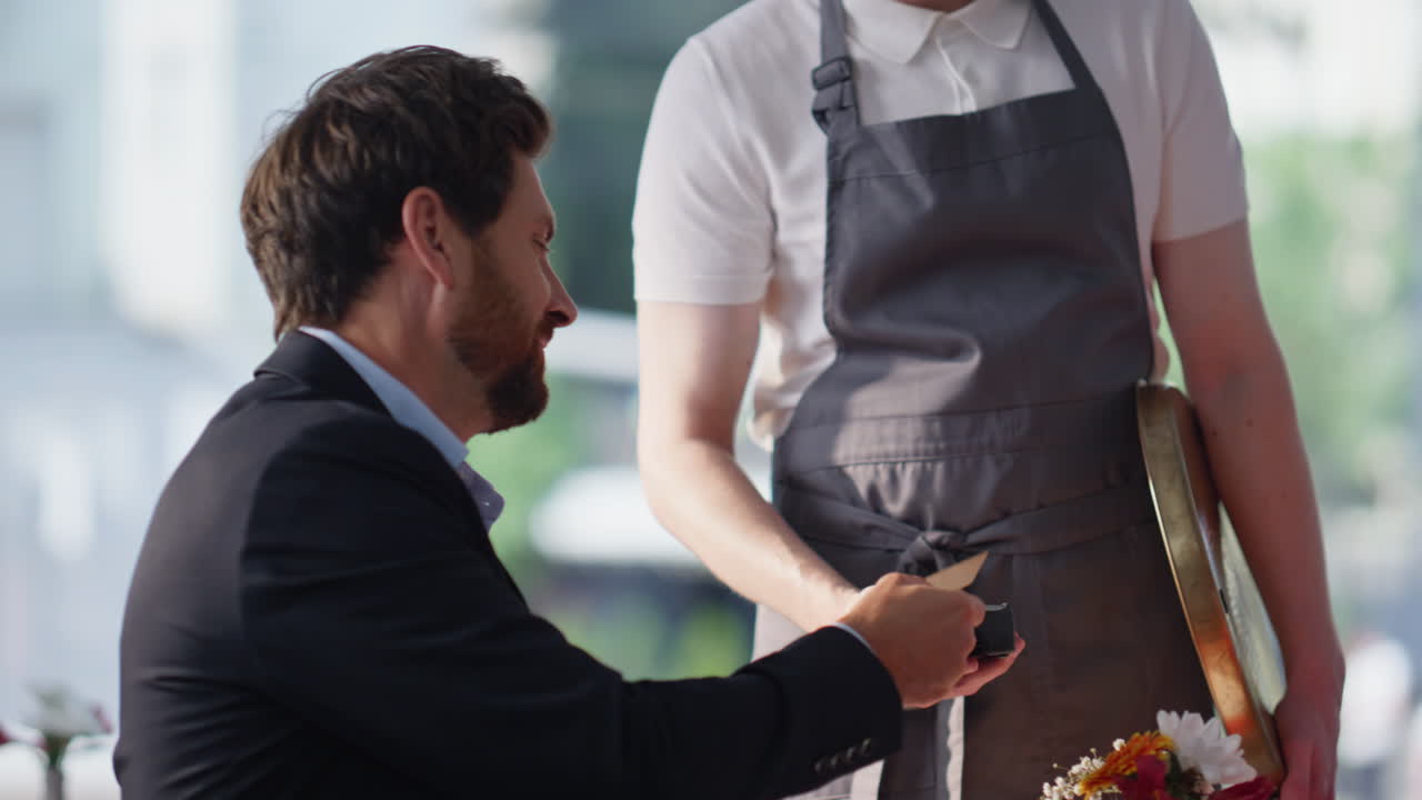 Elegant girlfriend talking boyfriend at restaurant closeup. Caring man paying