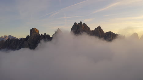 South-Tyrol-mountains-surrounded-by-clouds-aerial-view-reverse-over-hiker-watching-beautiful-landscape