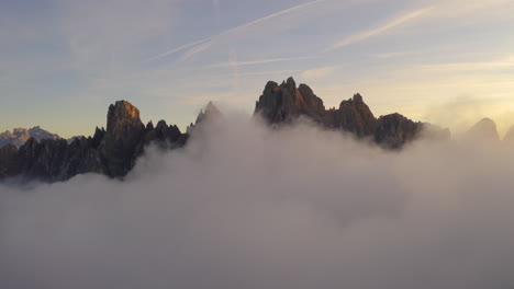 montañas del tirol del sur rodeadas de nubes vista aérea inversa sobre excursionista viendo hermoso paisaje