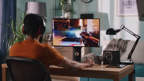 man playing a first-person shooter video game at home