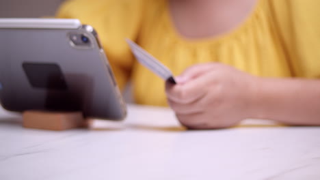 completar una compra y transacción en línea utilizando una tableta inteligente móvil mientras codifica la información necesaria de la cuenta de la tarjeta de crédito