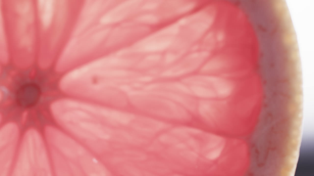 Micro video of close up of red grapefruit slice with copy space