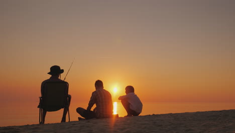 three children rest on the shore of the lake they are fishing recreation in the fresh air and live c