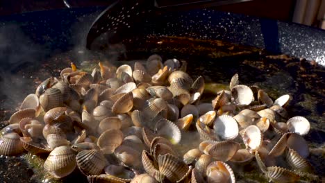 preparar paella tradicional española, freír mariscos