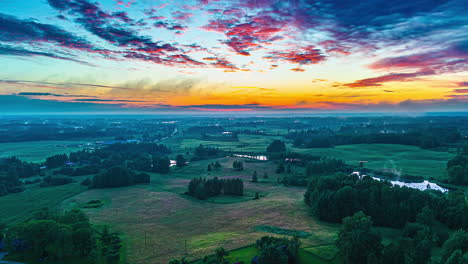 Sunset-over-countryside-farm-fields---high-altitude-aerial-hyper-lapse-through-low-clouds