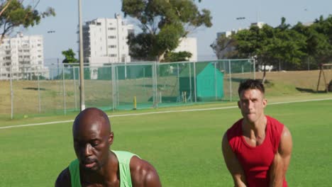 diverse group of three fit men exercising outdoors, singing kettlebell weights