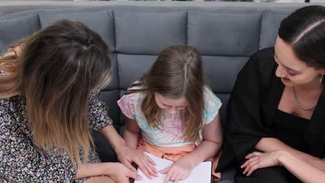 women and girl engaged in a learning discussion on a couch