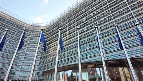 european commission entrance with waving eu flags in brussels