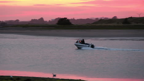 Small-fishing-boat-returns-to-harbour-at-sunset