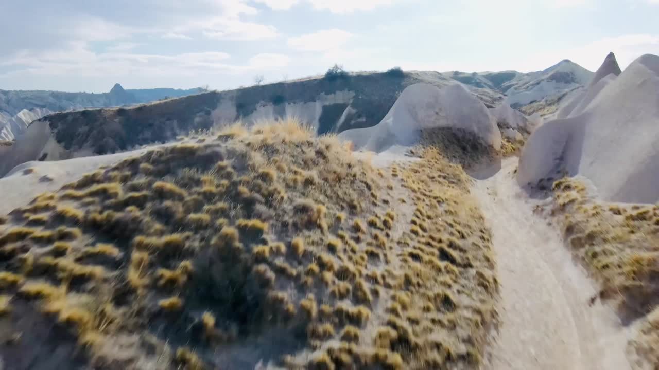 slow motion 60 fps drone footage of valley in Cappadocia turkey midday sunny beautiful landscape with pointy rocks and big mountains textures colors