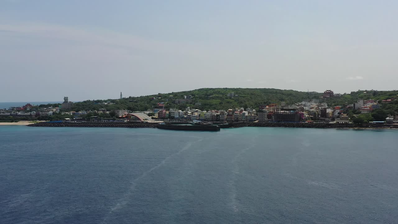 아름다운 바다 경치를 포착하는 공중 돌리, 대만 핑동 카운티 샤오리우치우 람바이 섬 어촌 마을의 다채로운 마을 풍경과 함께 다푸 항구를 향해 날아가는 드론