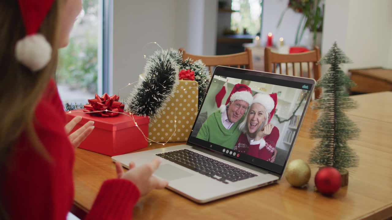 mujer caucásica feliz en videollamada con los abuelos en tiempo de navidad